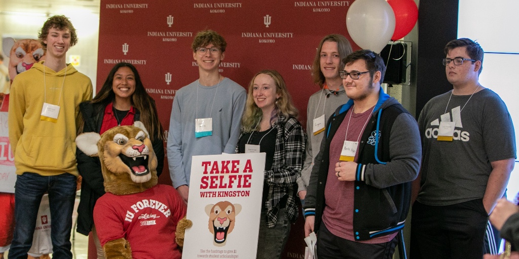 Several students standing with Kingston holding a sign.